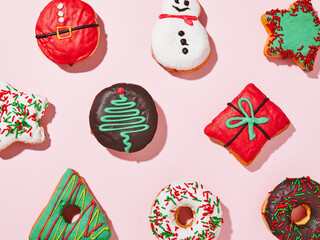 Variety of donuts isolated on pink background. Pastries and christmas concept.