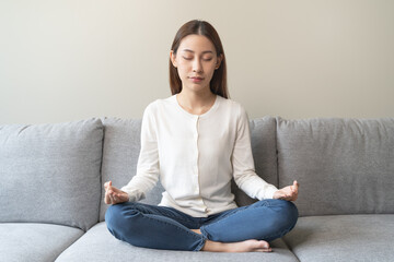 Wellbeing peaceful mind lifestyles,  Close up hand of young Asian women focus on breath harmony to refresh mindfulness on sofa in the living room at home.