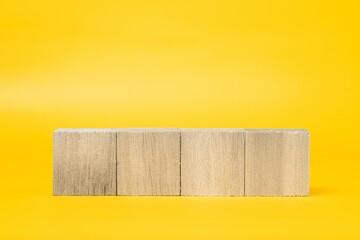 4つの木製のブロックと黄色背景　合成素材
