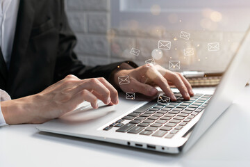 Businessman checking or sending online message on laptop with e-mail icons on background. Email...
