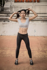 Young strong fit woman showing bicepses portrait in gym, looking away