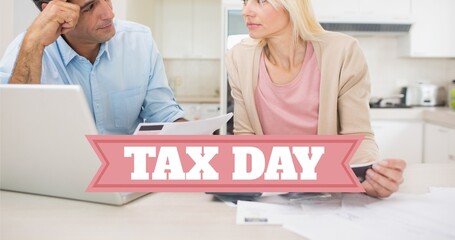 Tensed caucasian couple discussing over financial bills while filling returns behind tax day text
