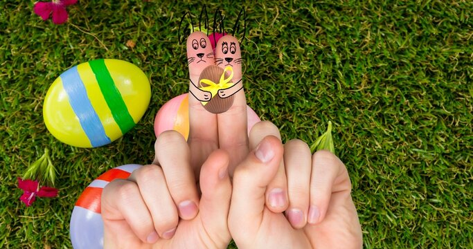 Creative easter bunnies cartoons on index fingers over eggs and grass