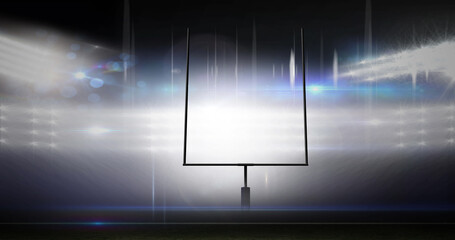 Image of american football goalposts and cloudy sky at floodlit stadium