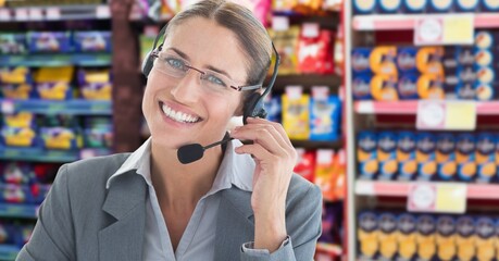 Composite image of caucasian businesswoman with phone headset smiling against supermarket