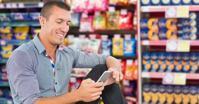 Composite image of caucasian man using smartphone against supermarket in background
