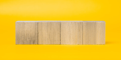 4つの木製のブロックと黄色背景　合成素材	
