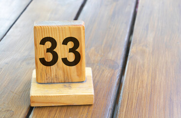 Wooden priority number 33 on a plank tab