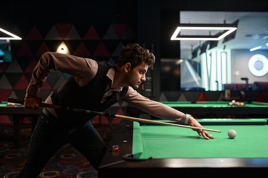 Portrait of young man aiming with billiards cue
