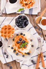 Waffles with blueberries and whipped cream.