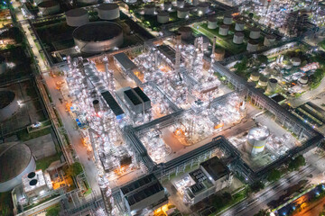 Aerial view of petrochemical oil refinery and sea in industrial engineering concept in Bangna district at night, Bangkok City, Thailand. Oil and gas tanks pipelines in industry. Modern metal factory.