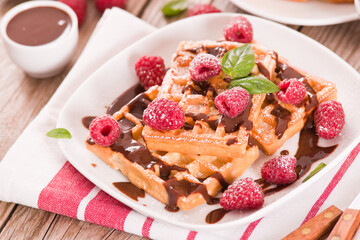 Waffles with raspberries and chocolate cream.