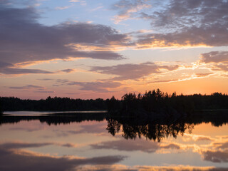 sunset with clouds over a forest lake