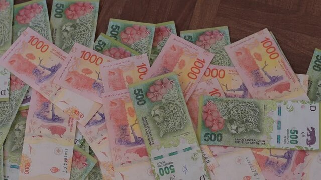 billetes de 500 pesos argentinos son apilados sobre otros billetes de 500 y 1000 pesos