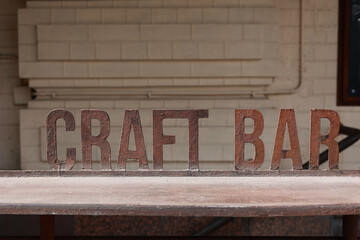 Obraz premium Iron signboard Craft Bar and bar counter. Entrance to a craft beer establishment.