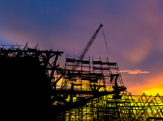 The concept of the building industry under construction silhouette and evening sun