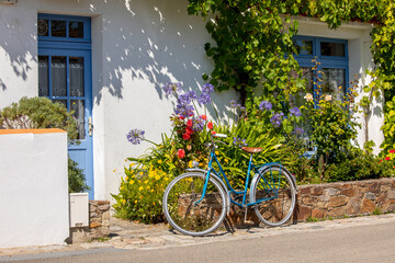 Fototapeta na wymiar Vieux vélo bleu dans les rues de l'île de Noirmoutier en Vendée, France.