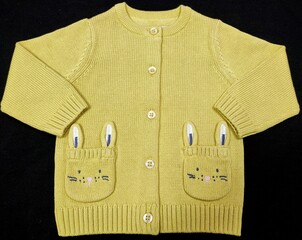 Yellow colour bunny pockets embroidery knit sweater and basic cardigan with buttons isolated knitted on the black background.