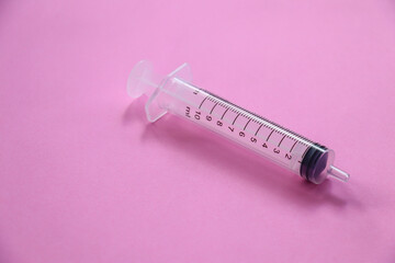 Syringe on a pink background, medical concept.