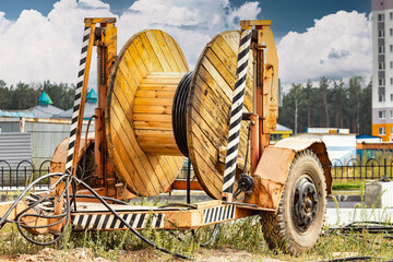 Wooden reel with high voltage cable mounted on a trailer for easy transport and stowage. Laying a...