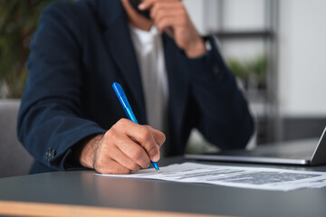 Arab businessman hand sign a contract on the desk, blurred backg