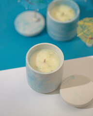 Soy candle in a concrete, plaster candlestick, decor interior. Home decoration with a burning scented candle. Spa. Natural.