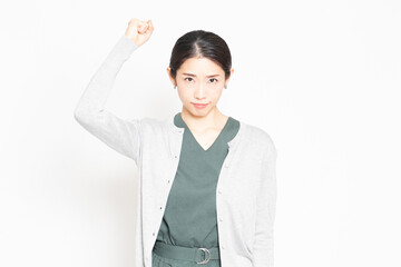 白背景の前に立って、怒っている女性