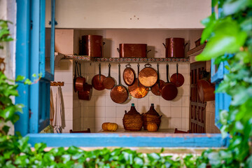 Antique copper kitchen utensils seen from a patio window in Cordoba, Spain