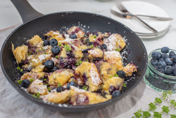 Kaiserschmarrn - traditional austrian pancake dessert with blueberries on a table