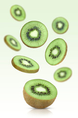 Levitation of sliced kiwi on a green background.