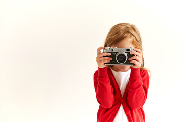 Beautiful smiling child (kid, girl) holding a instant camera