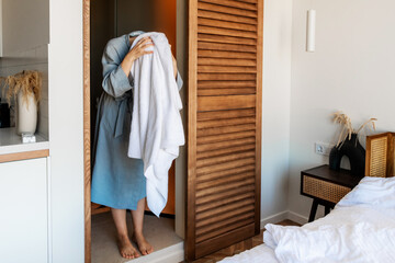woman wiping her hair with a towel after a shower