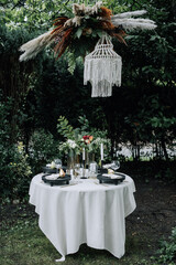 Modern wedding table decorated with plates, cutlery and flowers
