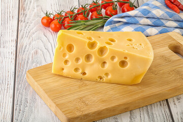 Maasdam cheese piece over board