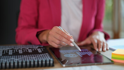 Tablet in female hands with financial figures and sales growth profit