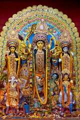 Fototapeta premium Divine idol of Hindu Goddess Durga slaying buffalo demon Mahishasura (asura), inside a puja pandal (temporary resting place for idol) during Durga puja festival in Kolkata, West Bengal.