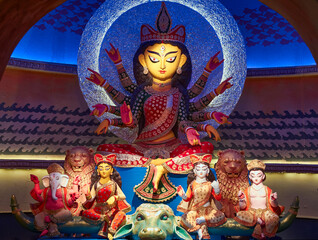 Divine idol of Hindu Goddess Durga slaying buffalo demon Mahishasura (asura), inside a puja pandal...
