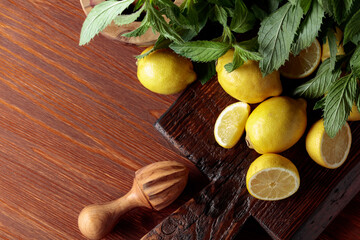 Fresh juicy lemons with mint on the old wooden table.