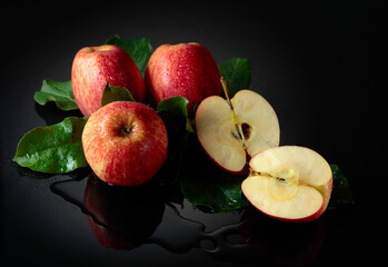 Fresh apples with drops of water on a black background.