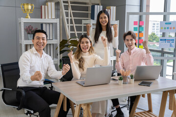 A group of Asian businessmen in casual clothes are meeting to present ideas for sustainable SME business. Everyone rejoiced that they succeeded in conquering the created business.