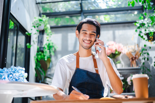 Asian Man Influencer Or SME Owner People Smile Work On Home Video Camera Selfie Shoot.Smiling Female Florist Talking On Mobile Phone. Young Woman Working At  Shop With Open Sign.