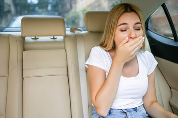 Unhappy  girl who will soon vomit due to car illness or indigestion, woman vomiting in the car, suffering from motion sickness or food poisoning, sad woman feeling  nauseous from motion sickness - obrazy, fototapety, plakaty
