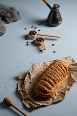 Puff pastry bun with sesame and condensed milk, homemade cakes and sweets, pastries for tea on a grey  background, valavan with condensed milk, coffee and pastries, bread products