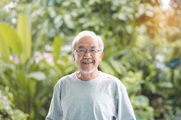 Portrait of asian senior smiling in laughing on green nature at park outdoor. Happy old man, woman enjoying feel emotions at garden backyard. Insurance Health care family lifestyle concept.