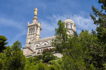 Fototapeta na wymiar Vue estivale sur la Basilique Notre-Dame de la Garde depuis le Chemin du Bois Sacré