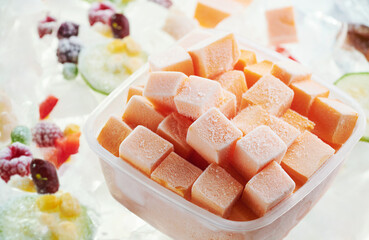 Closeup of chopped vegetables (pumpkin) in container on ice. Stocks of food consept. Top view.