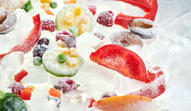 Background of frozen sliced vegetables on ice. Stocks of food consept. View above