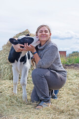 pretty black-white new born calf posing with farmer.