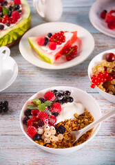 Granola, muesli cereals with yogurt or milk and fresh berries. Healthy breakfast concept.