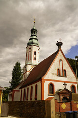 Naklejka premium Protestant parish church with a large stork nest on the roof in Otterwisch near Leipzig, Germany. The church dates back to the 12th century and has been rebuilt several times. 